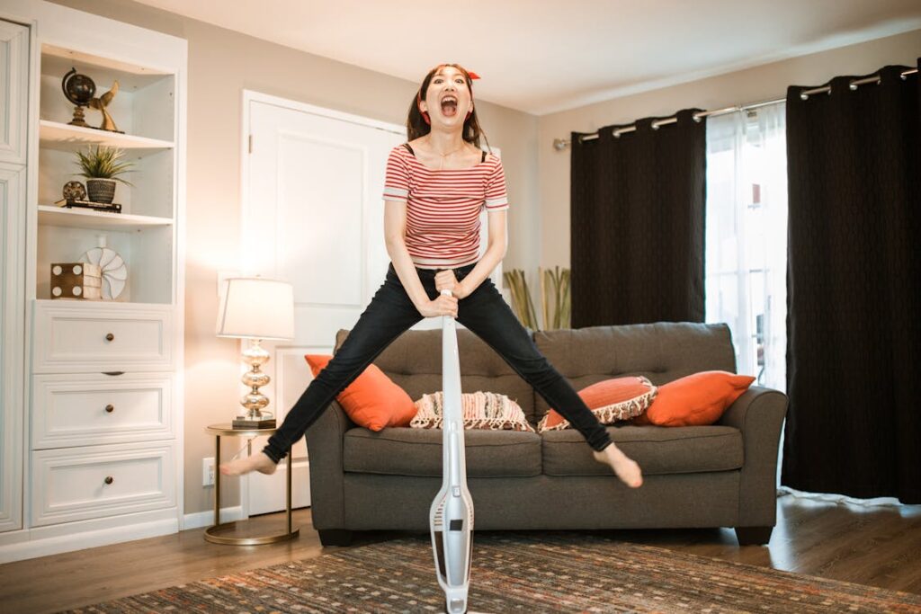 Free A Woman Vacuuming while Jumping Stock Photo